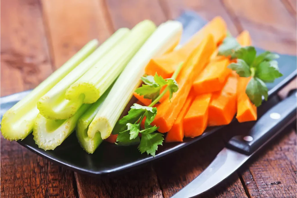 Chopped celery and carrots on a tray.